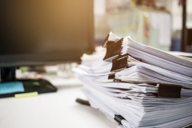 İşadamı elleri iş yerindeki evrak yığınlarında, iş raporlarında ya da tamamlanmamış belgelerde ofis içi ofis klipleriyle, iş konseptiyle ilgili bilgileri arıyor.