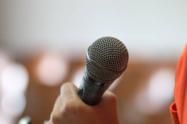 Seminerde iş adamlarının konuşmalarını ve mikrofonlarla konuşmalarını bulanıklaştıran, mikrofonlar ve açılış notlarıyla konferans salonunun ışığından bahseden. Konuşma insan iletişiminin seslendirilmiş biçimidir..