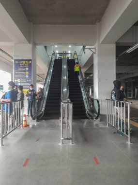 Tren istasyonunda yürüyen merdiven ve modern bir binanın içi.