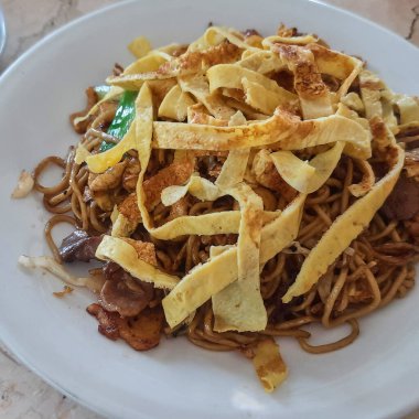 Lokantada dilimlenmiş omletle birlikte beyaz tabakta Çin mutfağı.