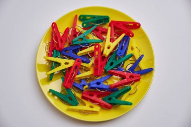 Sarı tabakta çok renkli çamaşır klipsleri