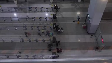 Havaalanının giriş kapısında bavulla yürüyen insanların hava görüntüsü.