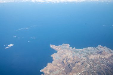 Uluslararası uçuş sırasında uçaktan hava görüntüsü. Uçakla seyahat, yukarıdan manzara ve bulutlar.