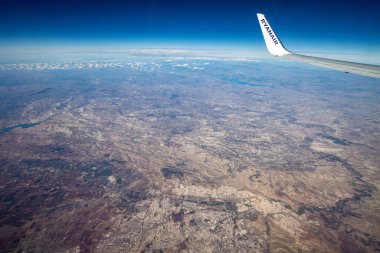 Uçak yolculuğu sırasında gökyüzündeki bulutlar. Bulutların manzarası ve hareket halindeki bir uçağın penceresinden alınan karasal ufuk. Pencere manzaralı düzlemle seyahat et.