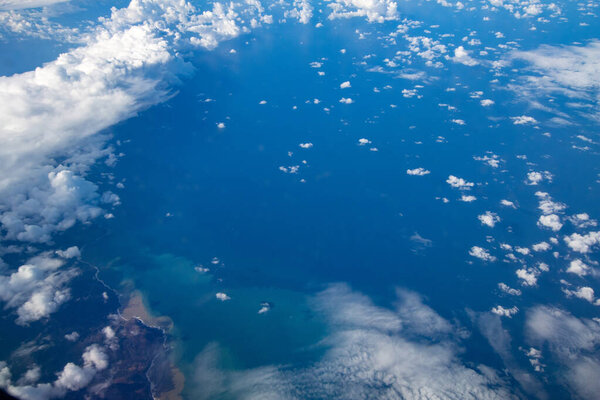 Вид с самолета во время международного полета. Путешествие на самолете, пейзаж сверху и облака.