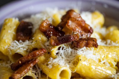 Bir tabak Carbonara makarnasının ayrıntıları. Tipik İtalyan ve Roma mutfağı. Pastırma ve yumurta gibi rigatoni guanciale soslu makarna. Makarna, İtalyan mutfağı.