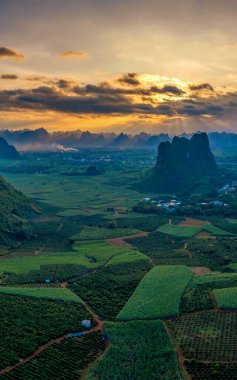 Daxin County, Guangxi, Çin 'in günbatımı manzarası. Tepeleri, ormanları ve tarlaları alacakaranlık parıltısıyla yıkanmış..