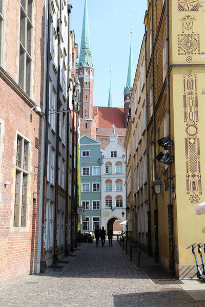 Beautiful architecture of the old streets of Gdansk, Poland. Multicolored houses, flowers, drawbridges, fancy signs. sculptures and fountains. Warm spring days before the beginning of tourist season