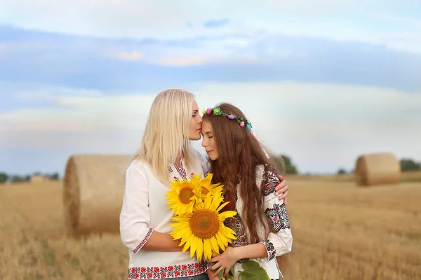 乌克兰母亲拥抱并亲吻着女儿 她们都穿着绣花衬衫 戴着一束向日葵花 爱乌克兰的概念 独立日 乌克兰宪法 — 图库照片