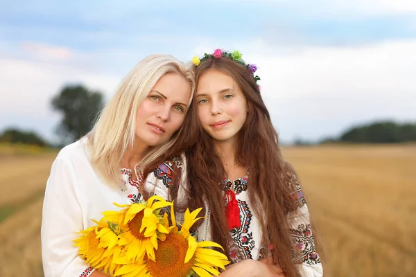 Українська Мати Обіймає Цілує Дочку Носячи Вишиті Сорочки Букетом Соняшника — стокове фото