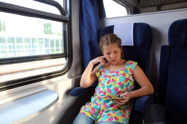Kız ikinci sınıf kompartıman vagonunda trenle seyahat ediyor. Pencereden dışarı bakıyor, okuyor, akıllı telefon kullanarak online seyahat dersleri planlıyor. Yaz tatilleri, aktif seyahat tatilleri