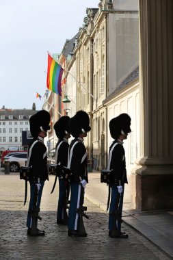 Kopenhag, Danimarka-Ağustos 17, 2023: Onur Sarayı 'nın yakınındaki sarayın muhafızlarının değiştirilmesi. Garder Hussarları. Saray cephesinde gökkuşağı LGBT bayrağının arka planına karşı muhafız.