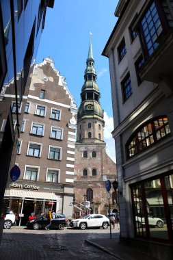 Riga sokaklarında yeni ve eski binalar topluluğu. Aziz Peter Bazilikası 'nın çan kulesi. Cam cephelerdeki eski binaların yansıması.