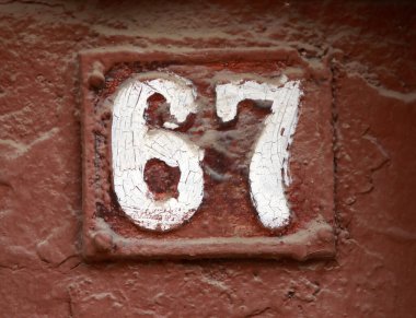 Eski model, kare, paslı, paslı bir plaka. Adres numarası da var. Yaklaş, marka..