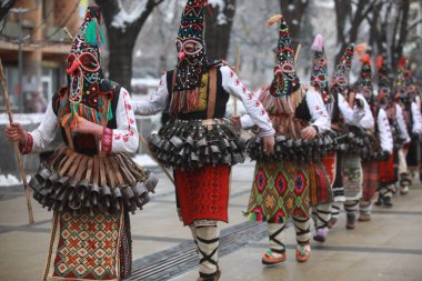 Pernik, Bulgaria - January 27, 2023: International masquerade festival Surva in Pernik, Bulgaria. People with mask called Kukeri dance and perform to scare the evil spirits.