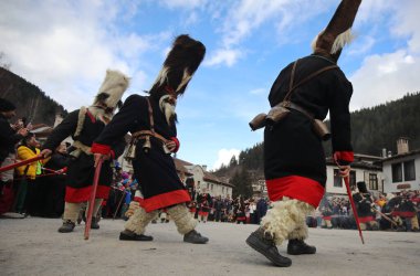 Shiroka laka, Bulgaristan - 5 Mart 2023: Bulgaristan 'ın Shiroka laka kentinde düzenlenen Maskeli Balo Festivali' nde maskeli insanlar dans ediyor ve kötü ruhları korkutmak için gösteri yapıyorlar..