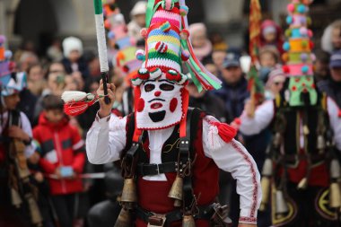 Shiroka laka, Bulgaristan - 5 Mart 2023: Bulgaristan 'ın Shiroka laka kentinde düzenlenen Maskeli Balo Festivali' nde maskeli insanlar dans ediyor ve kötü ruhları korkutmak için gösteri yapıyorlar..