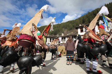 Shiroka laka, Bulgaristan - 5 Mart 2023: Bulgaristan 'ın Shiroka laka kentinde düzenlenen Maskeli Balo Festivali' nde maskeli insanlar dans ediyor ve kötü ruhları korkutmak için gösteri yapıyorlar..