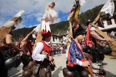 Shiroka laka, Bulgaristan - 5 Mart 2023: Bulgaristan 'ın Shiroka laka kentinde düzenlenen Maskeli Balo Festivali' nde maskeli insanlar dans ediyor ve kötü ruhları korkutmak için gösteri yapıyorlar..