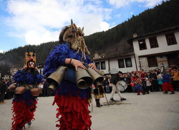 Shiroka laka, Bulgaria - March 5, 2023: People with mask called Kukeri dance and perform to scare the evil spirits at the Festival of the Masquerade Games "Pesponedelnik" in Shiroka laka, Bulgaria.