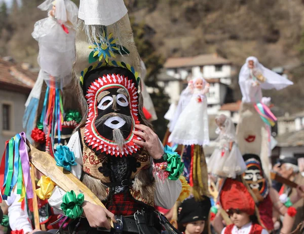 Shiroka laka, Bulgaristan - 5 Mart 2023: Bulgaristan 'ın Shiroka laka kentinde düzenlenen Maskeli Balo Festivali' nde maskeli insanlar dans ediyor ve kötü ruhları korkutmak için gösteri yapıyorlar..