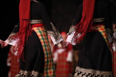Sofya, Bulgaristan - 11 Mart 2023: Geleneksel folklor kostümlü insanlar Bulgaristan 'ın Sofya kentindeki Ulusal Folklor Meclisi' nde halk dansı yaptılar
