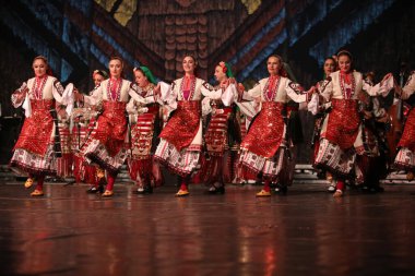 Sofya, Bulgaristan - 11 Mart 2023: Geleneksel folklor kostümlü insanlar Bulgaristan 'ın Sofya kentindeki Ulusal Folklor Meclisi' nde halk dansı yaptılar