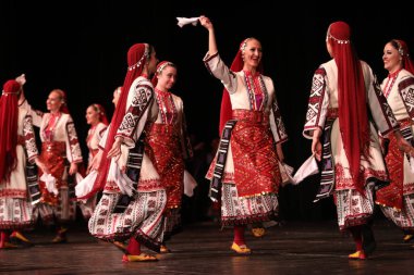 Sofya, Bulgaristan - 11 Mart 2023: Geleneksel folklor kostümlü insanlar Bulgaristan 'ın Sofya kentindeki Ulusal Folklor Meclisi' nde halk dansı yaptılar