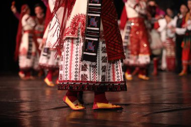 Sofya, Bulgaristan - 11 Mart 2023: Geleneksel folklor kostümlü insanlar Bulgaristan 'ın Sofya kentindeki Ulusal Folklor Meclisi' nde halk dansı yaptılar