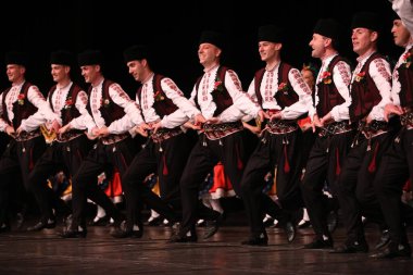 Sofya, Bulgaristan - 11 Mart 2023: Geleneksel folklor kostümlü insanlar Bulgaristan 'ın Sofya kentindeki Ulusal Folklor Meclisi' nde halk dansı yaptılar