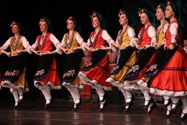 Sofya, Bulgaristan - 11 Mart 2023: Geleneksel folklor kostümlü insanlar Bulgaristan 'ın Sofya kentindeki Ulusal Folklor Meclisi' nde halk dansı yaptılar
