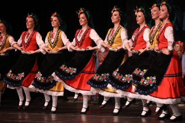 Sofya, Bulgaristan - 11 Mart 2023: Geleneksel folklor kostümlü insanlar Bulgaristan 'ın Sofya kentindeki Ulusal Folklor Meclisi' nde halk dansı yaptılar