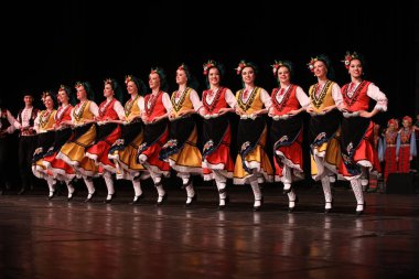 Sofya, Bulgaristan - 11 Mart 2023: Geleneksel folklor kostümlü insanlar Bulgaristan 'ın Sofya kentindeki Ulusal Folklor Meclisi' nde halk dansı yaptılar