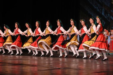 Sofya, Bulgaristan - 11 Mart 2023: Geleneksel folklor kostümlü insanlar Bulgaristan 'ın Sofya kentindeki Ulusal Folklor Meclisi' nde halk dansı yaptılar