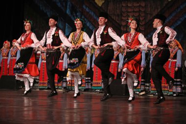 Sofya, Bulgaristan - 11 Mart 2023: Geleneksel folklor kostümlü insanlar Bulgaristan 'ın Sofya kentindeki Ulusal Folklor Meclisi' nde halk dansı yaptılar