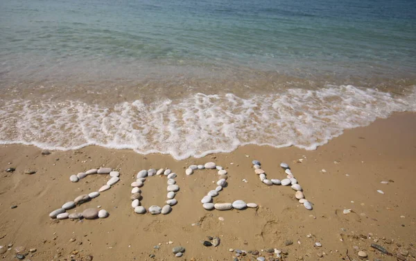 新しい2024年 波と澄んだ青い海でビーチにレタリング 海岸の数 2024 美しいビーチの背景に黄金の砂に手書きされたメッセージ 新年コンセプト ストックフォト