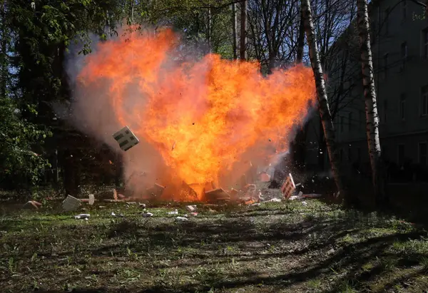 Fire from a large explosion between green trees