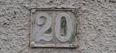 Eski model, kare, paslı, paslı bir plaka. Adres numarası da var. Yaklaş, marka..