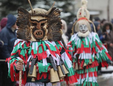 Breznik, Bulgaristan - 20 Ocak 2024: Bulgaristan 'ın Breznik kentinde düzenlenen Maskeli Balo Festivali' nde geleneksel Kukeri kostümlü tanımlanamayan kişiler görülüyor.