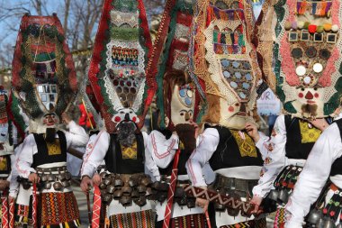 Pernik, Bulgaristan - 26 Ocak 2024: Bulgaristan 'ın Pernik kentinde düzenlenen uluslararası maskeli balo festivali Surva. Kukeri adındaki maskeli insanlar dans ediyor ve kötü ruhları korkutmak için gösteri yapıyorlar..