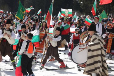 Pamporovo, Bulgaria - March 03, 2024 - Skiing with Bulgarian flags at Pamporovo ski resort, Bulgaria. People dressed with traditional Bulgarian clothes celebrated by ski parade with the Bulgarian flag downhill the Snezhanka peak clipart