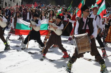 Pamporovo, Bulgaria - March 03, 2024 - Skiing with Bulgarian flags at Pamporovo ski resort, Bulgaria. People dressed with traditional Bulgarian clothes celebrated by ski parade with the Bulgarian flag downhill the Snezhanka peak clipart