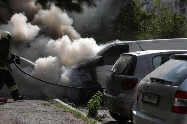 Sofya, Bulgaristan - 30 Haziran 2024: İtfaiyeciler Bulgaristan 'ın başkenti Sofya' daki Nadezhda 'daki bir konut binasının önündeki iki araca yangın çıkardılar