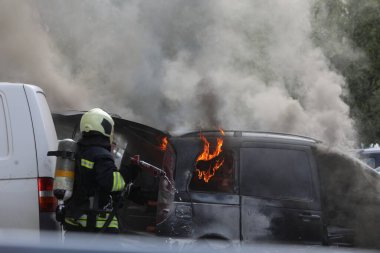 Sofya, Bulgaristan - 30 Haziran 2024: İtfaiyeciler Bulgaristan 'ın başkenti Sofya' daki Nadezhda 'daki bir konut binasının önündeki iki araca yangın çıkardılar