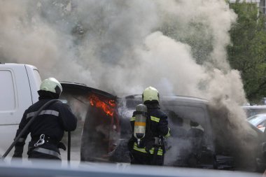 Sofya, Bulgaristan - 30 Haziran 2024: İtfaiyeciler Bulgaristan 'ın başkenti Sofya' daki Nadezhda 'daki bir konut binasının önündeki iki araca yangın çıkardılar