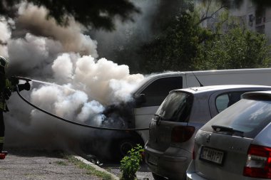 Sofya, Bulgaristan - 30 Haziran 2024: İtfaiyeciler Bulgaristan 'ın başkenti Sofya' daki Nadezhda 'daki bir konut binasının önündeki iki araca yangın çıkardılar