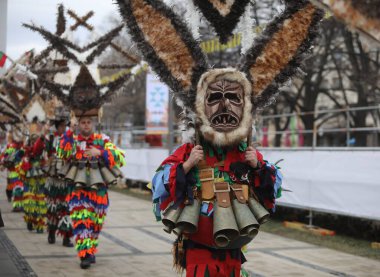Pernik, Bulgaristan - 24 Ocak 2025: Bulgaristan 'ın Pernik kentinde düzenlenen 31. Uluslararası Maskeli Balo Festivali Surva. Kukeri adındaki maskeli insanlar dans ediyor ve kötü ruhları korkutmak için gösteri yapıyorlar..