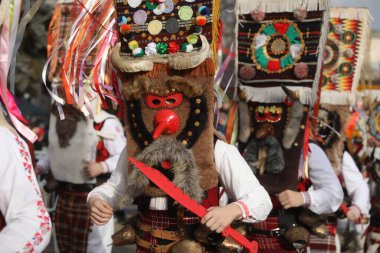 Pernik, Bulgaristan - 24 Ocak 2025: Bulgaristan 'ın Pernik kentinde düzenlenen 31. Uluslararası Maskeli Balo Festivali Surva. Kukeri adındaki maskeli insanlar dans ediyor ve kötü ruhları korkutmak için gösteri yapıyorlar..