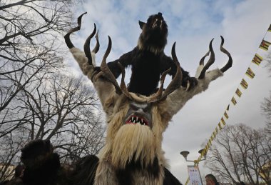 Pernik, Bulgaria - January 24, 2025: The 31th International masquerade festival Surva in Pernik, Bulgaria. People with mask called Kukeri dance and perform to scare the evil spirits. clipart