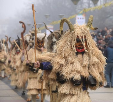 Pernik, Bulgaria - January 25, 2025: The 31th International masquerade festival Surva in Pernik, Bulgaria. People with mask called Kukeri dance and perform to scare the evil spirits. clipart